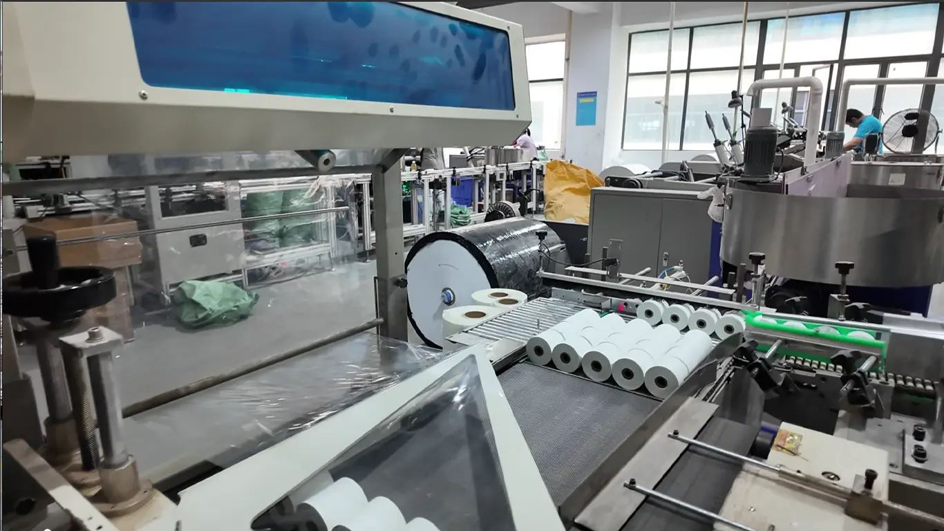 Thermal paper rolls moving through production equipment
